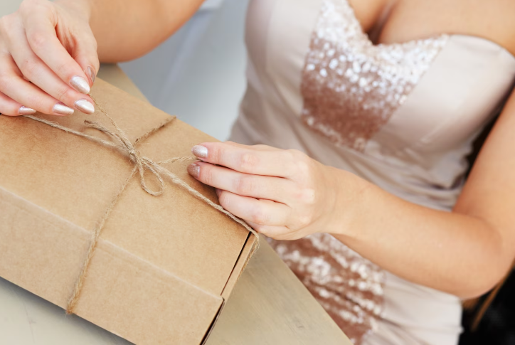 Novia abriendo un obsequio y esperando que sean ideas originales para regalo de casamiento